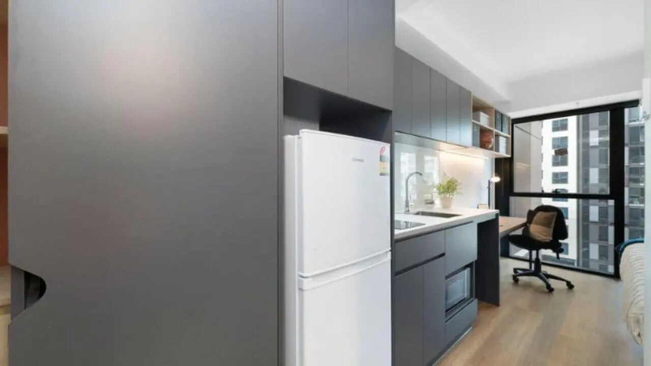White fridge microwave grey cabinets sink study area kitchen at UniLodge Melbourne Central in Melbourne Student Accommodation