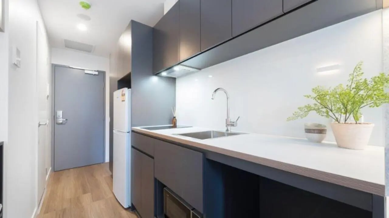 Modern kitchenette with sink refrigerator and cabinets kitchen at UniLodge Melbourne Central in Melbourne Student Accommodation