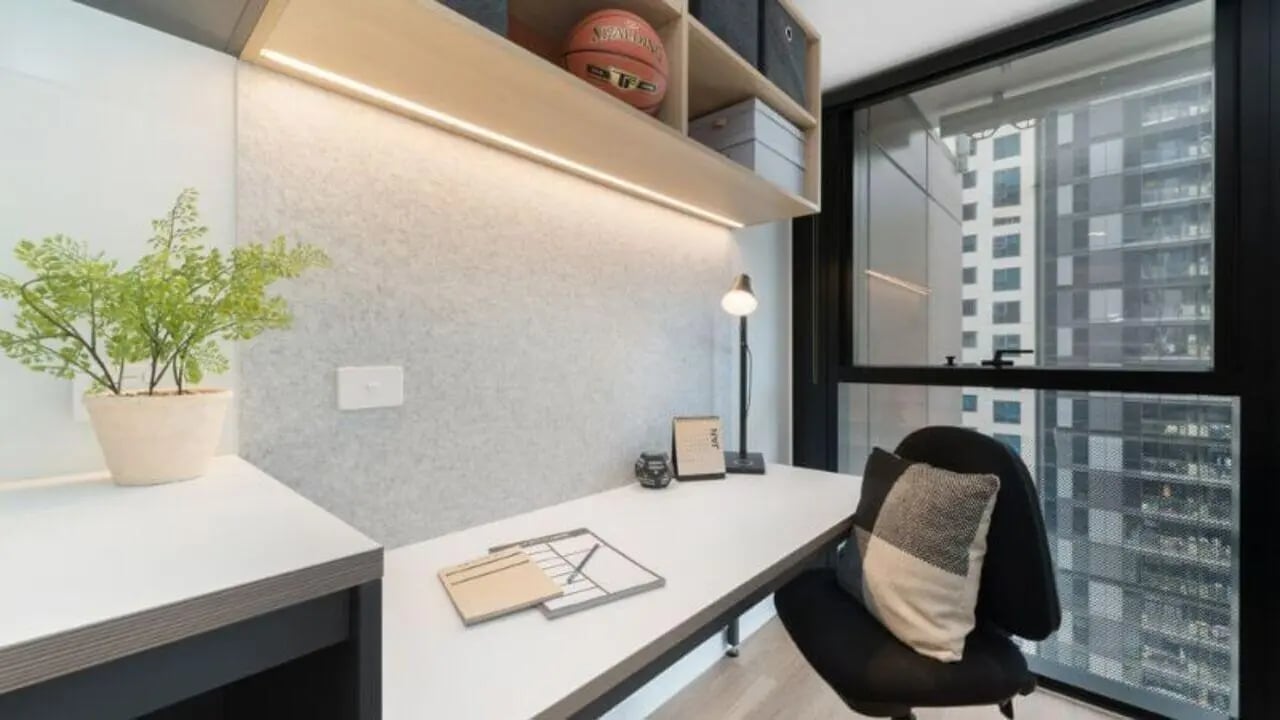 Desk plant lamp chair and city view study area at UniLodge Melbourne Central in Melbourne Student Accommodation