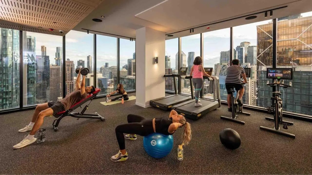 Gym equipment with people working out gym at UniLodge Melbourne Central in Melbourne Student Accommodation