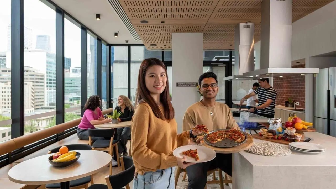 People with pizza in student kitchen common area at UniLodge Melbourne Central in Melbourne Student Accommodation