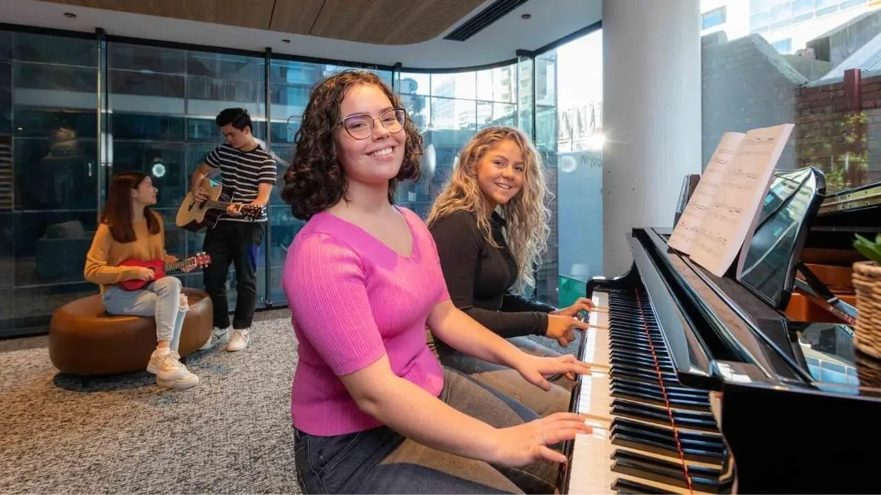 Students playing piano guitars ukulele common area at UniLodge Melbourne Central in Melbourne Student Accommodation
