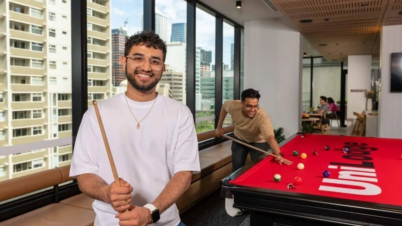 Students playing billiards with city view playing area at UniLodge Melbourne Central in Melbourne Student Accommodation