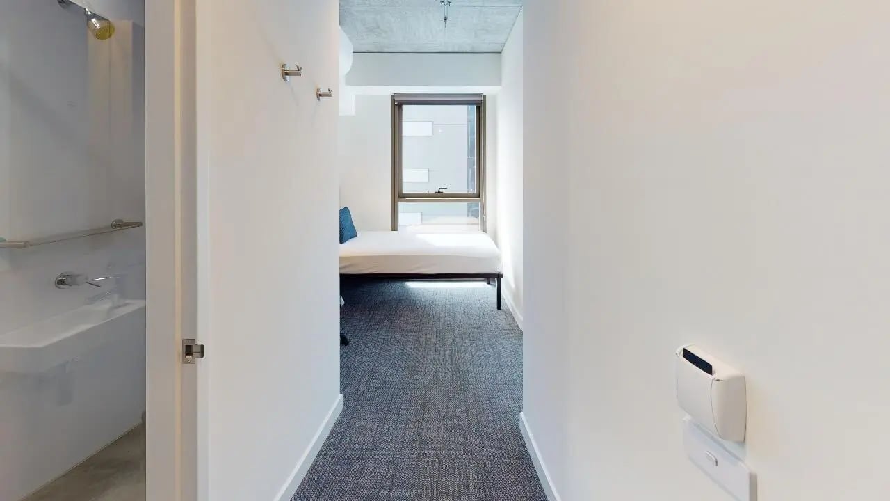 Bed with blue pillow and sink bedroom bathroom at Unilodge Melbourne City in Melbourne Student Accommodation