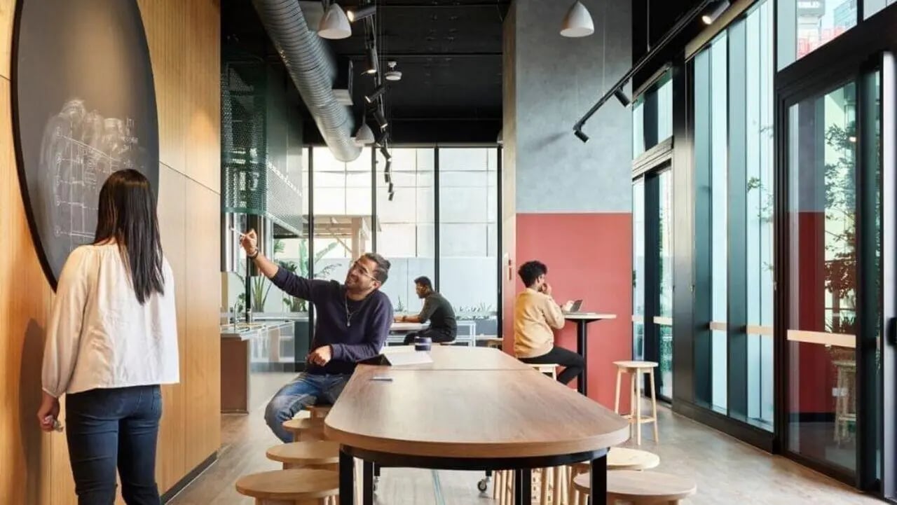 Students collaborating at a shared table and chalkboard area at Unilodge Melbourne City in Melbourne Student Accommodation
