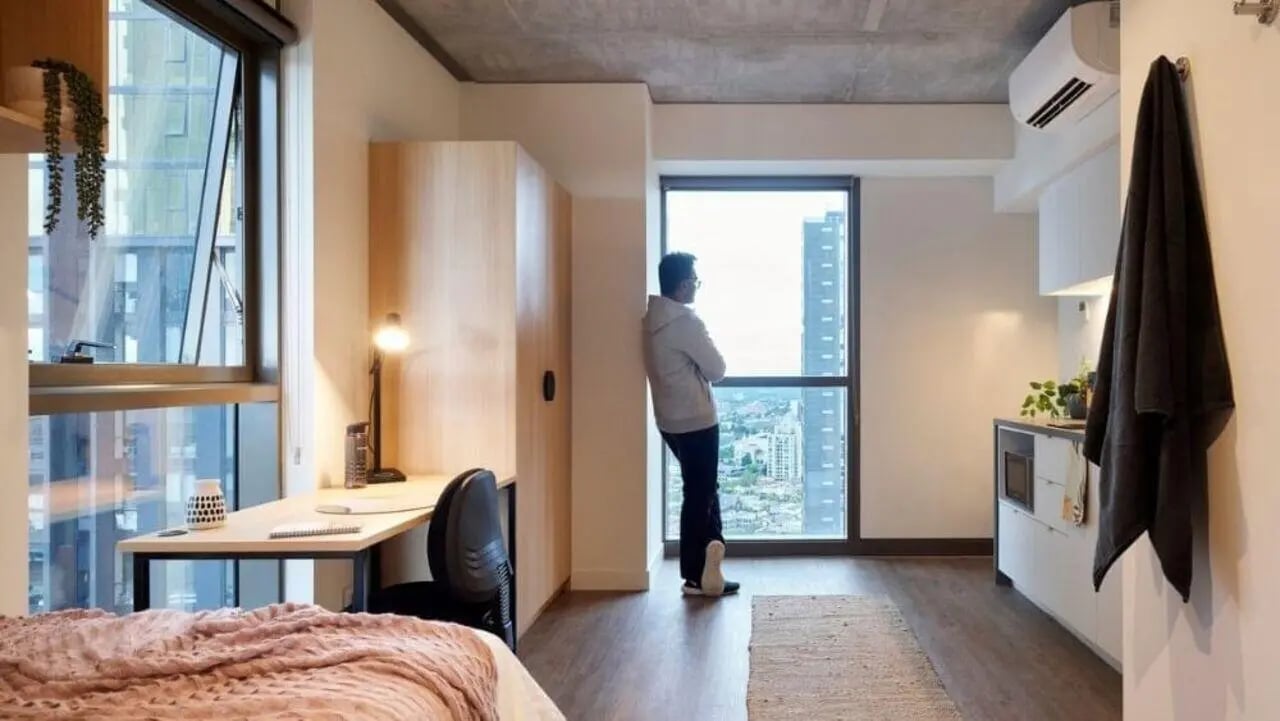 Bed desk wardrobe and kitchen student studio apartment at Unilodge Melbourne City in Melbourne Student Accommodation