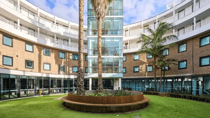 Courtyard with seating and palm trees exterior at UniLodge Park Avenue in Melbourne Student Accommodation
