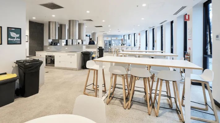 Kitchen counters tables chairs and bins kitchen at UniLodge Park Avenue in Melbourne Student Accommodation