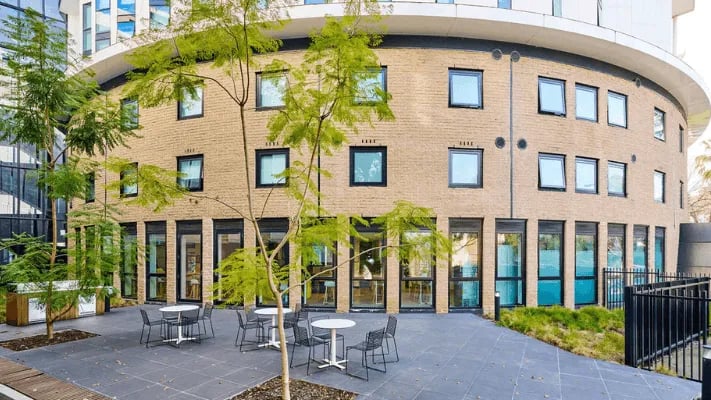 Outdoor seating area tables chairs building exterior at UniLodge Park Avenue in Melbourne Student Accommodation