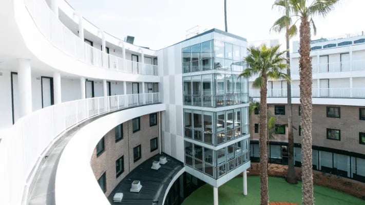 Modern curved building with balconies and glass exterior exterior at UniLodge Park Avenue in Melbourne Student Accommodation