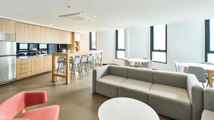 Kitchen with sofa tables and chairs living area at UniLodge Park Avenue in Melbourne Student Accommodation