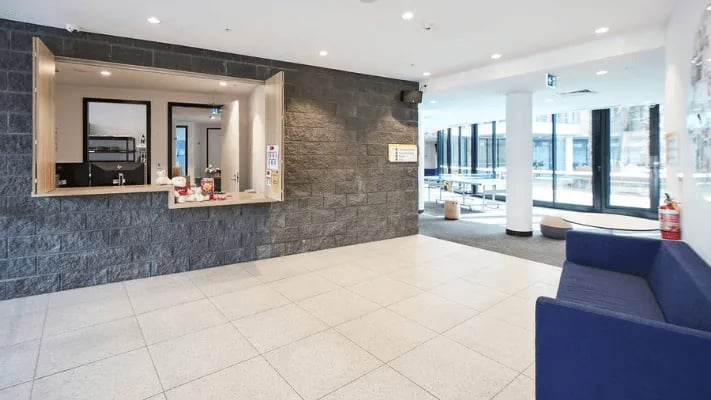 Reception desk with computer and seating area lobby at UniLodge Park Avenue in Melbourne Student Accommodation