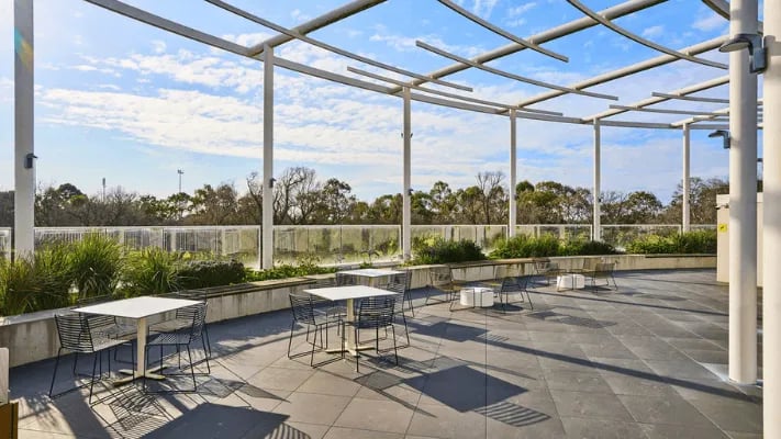 Outdoor tables and chairs under pergola exterior at UniLodge Park Avenue in Melbourne Student Accommodation