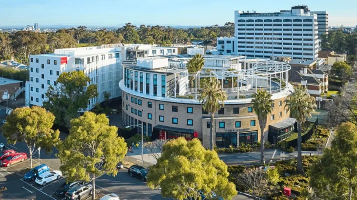 Modern curved building with large windows parking exterior at UniLodge Park Avenue in Melbourne Student Accommodation