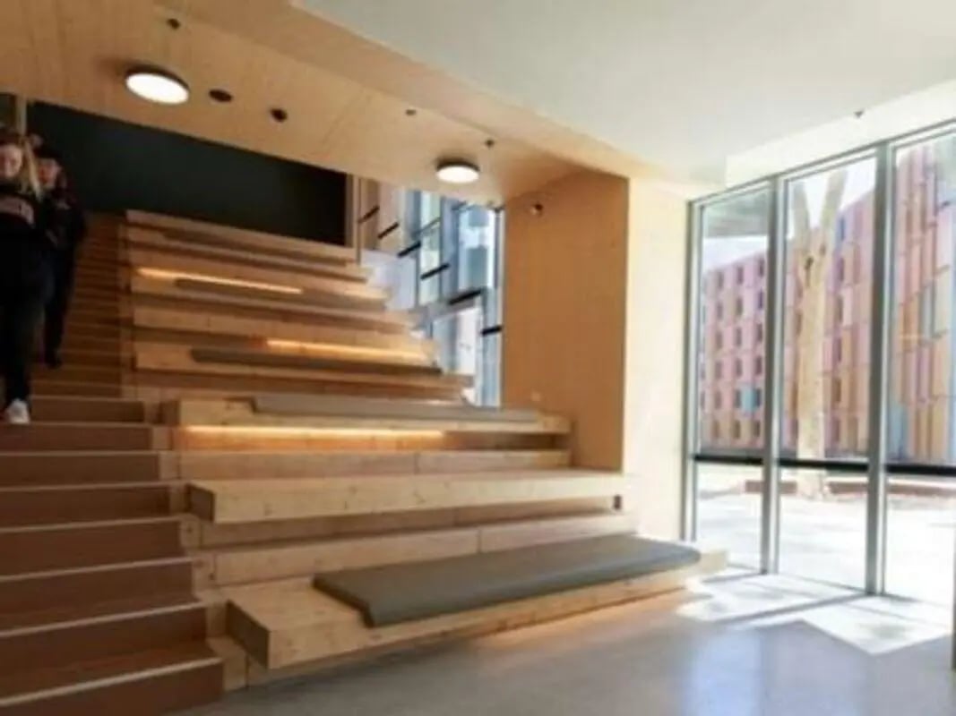 Wooden tiered seating with cushions staircase area at La Trobe University - North and South Apartments in Melbourne Student Accommodation
