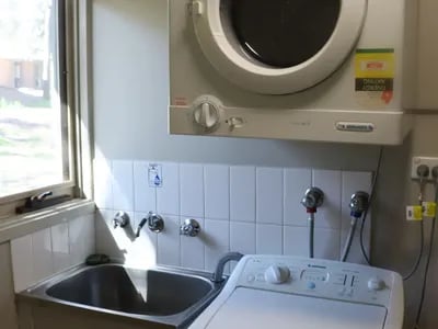 Washer dryer above sink and taps laundry room at La Trobe University - Villas in Melbourne Student Accommodation