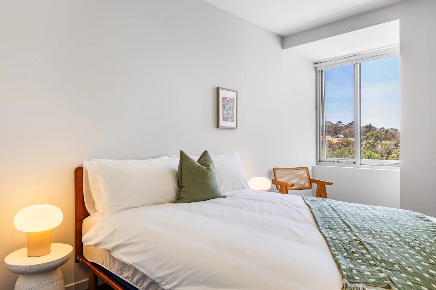 Bed with green pillows and patterned throw bedroom at UKO Royal Park in Melbourne Student Accommodation