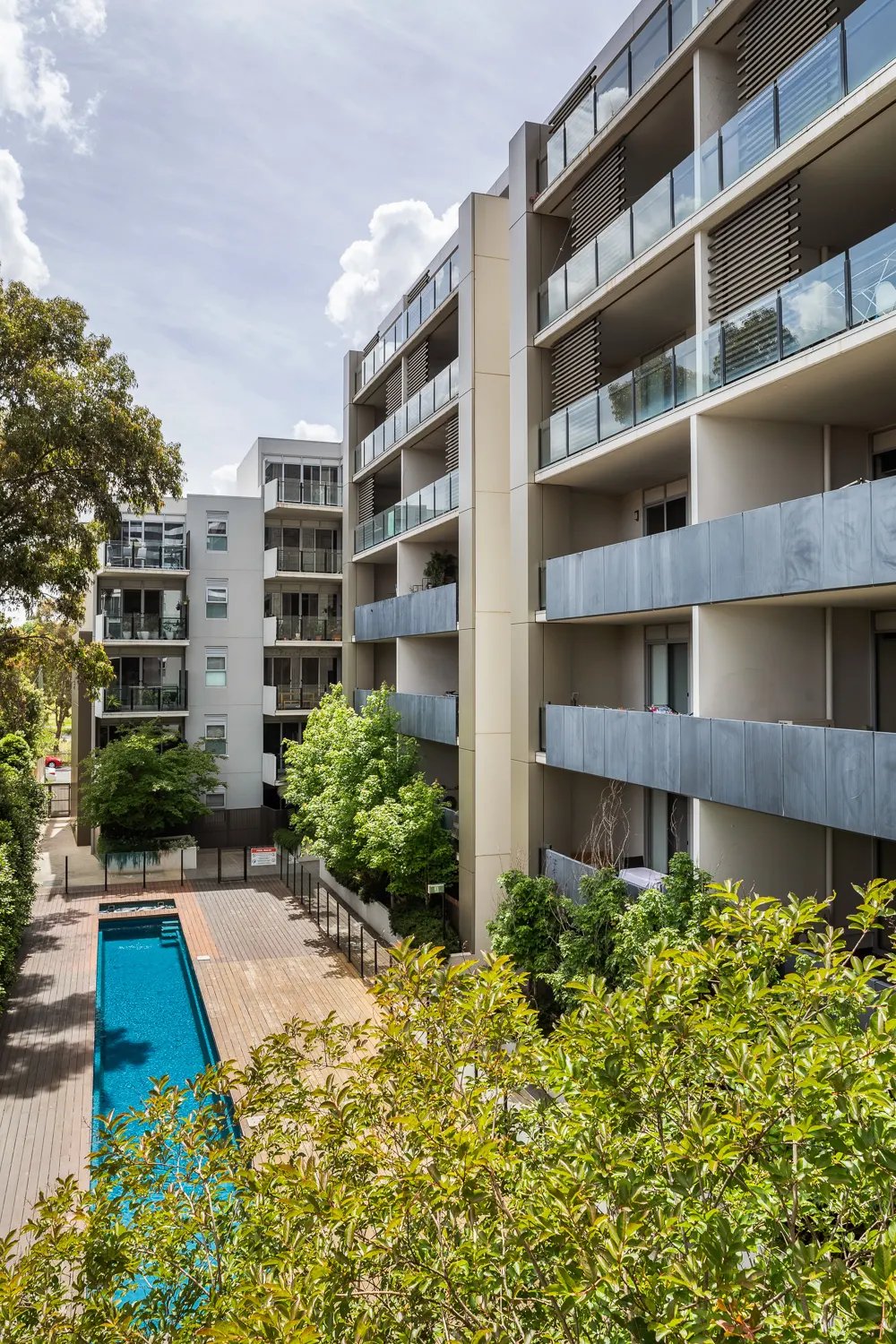Apartment buildings with balconies and pool exterior at UKO Royal Park in Melbourne Student Accommodation