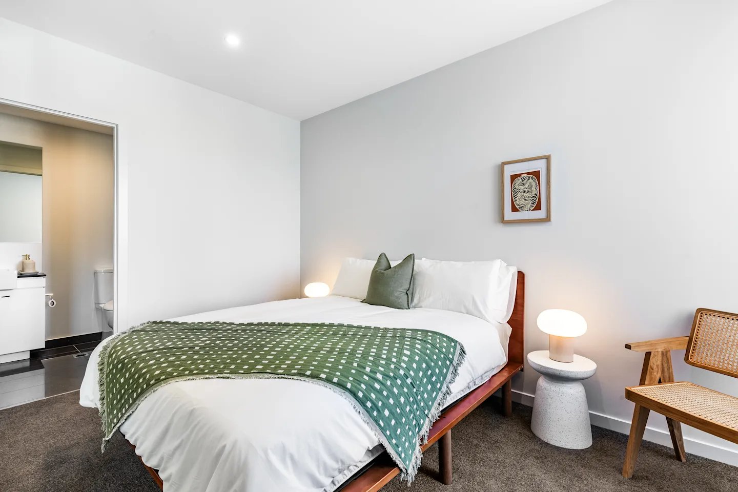 Bed with green throw bedside lamp and chair bedroom at UKO Royal Park in Melbourne Student Accommodation