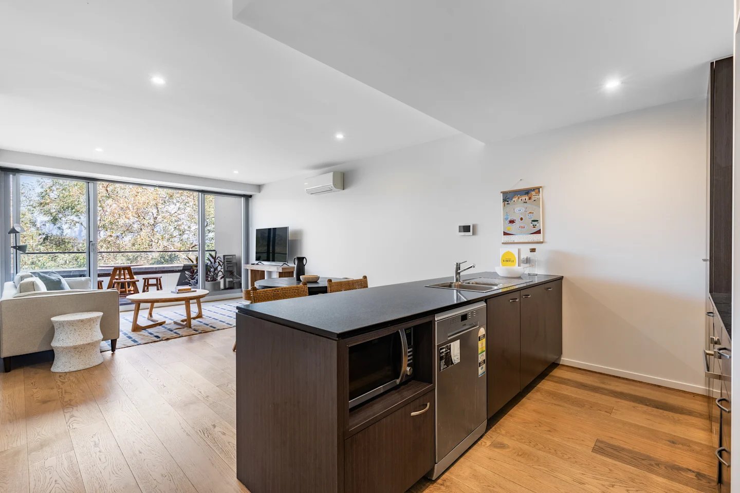 Sofa coffee table TV kitchen island living area kitchen at UKO Royal Park in Melbourne Student Accommodation