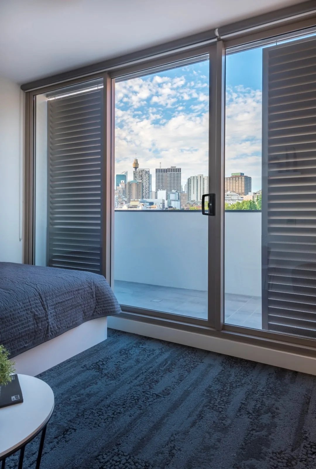 Bed carpet and city view bedroom at UKO Surry Hills in Sydney Student Accommodation