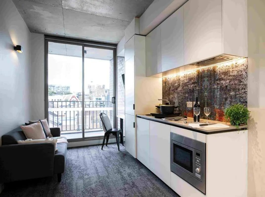 Sofa microwave oven kitchen counter wine glasses kitchen at UKO Surry Hills in Sydney Student Accommodation