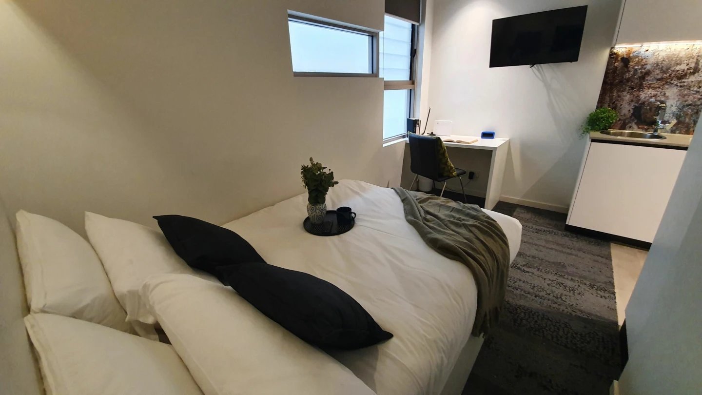 Bed desk TV sink kitchen studio apartment at UKO Surry Hills in Sydney Student Accommodation