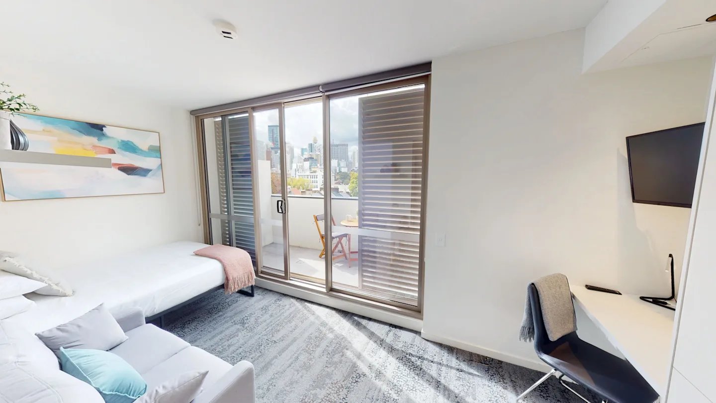 Bed sofa desk TV with city view living room at UKO Surry Hills in Sydney Student Accommodation