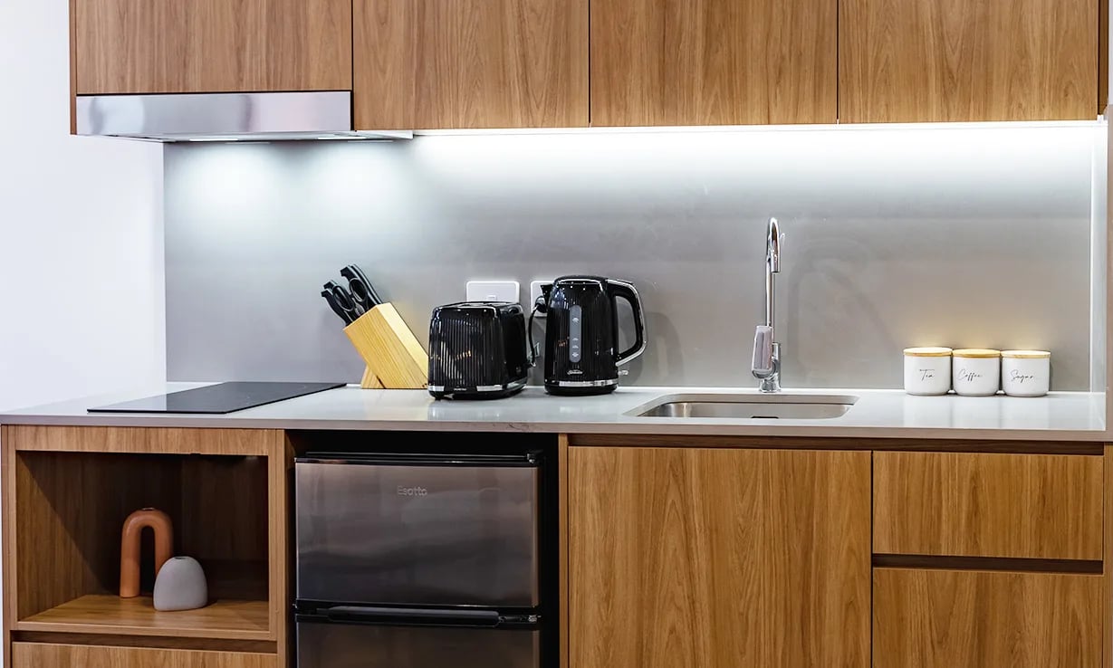 Kitchen counter with toaster kettle sink and cabinets kitchen at UKO Sutherland in Sydney Student Accommodation