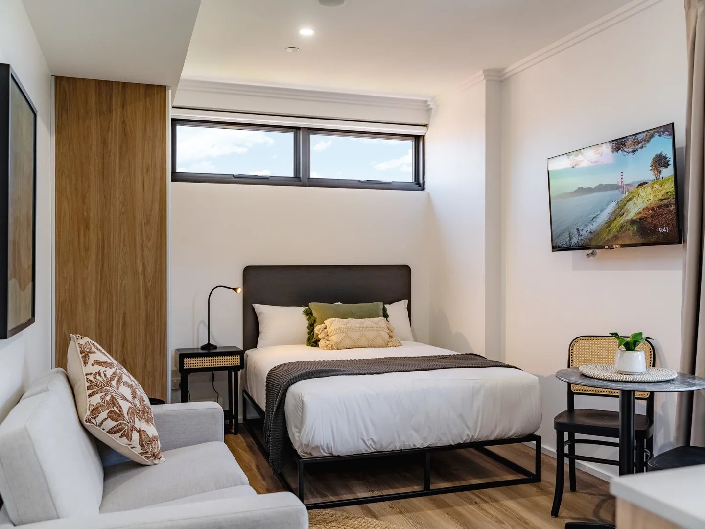 Bed sofa table and TV bedroom at UKO Sutherland in Sydney Student Accommodation