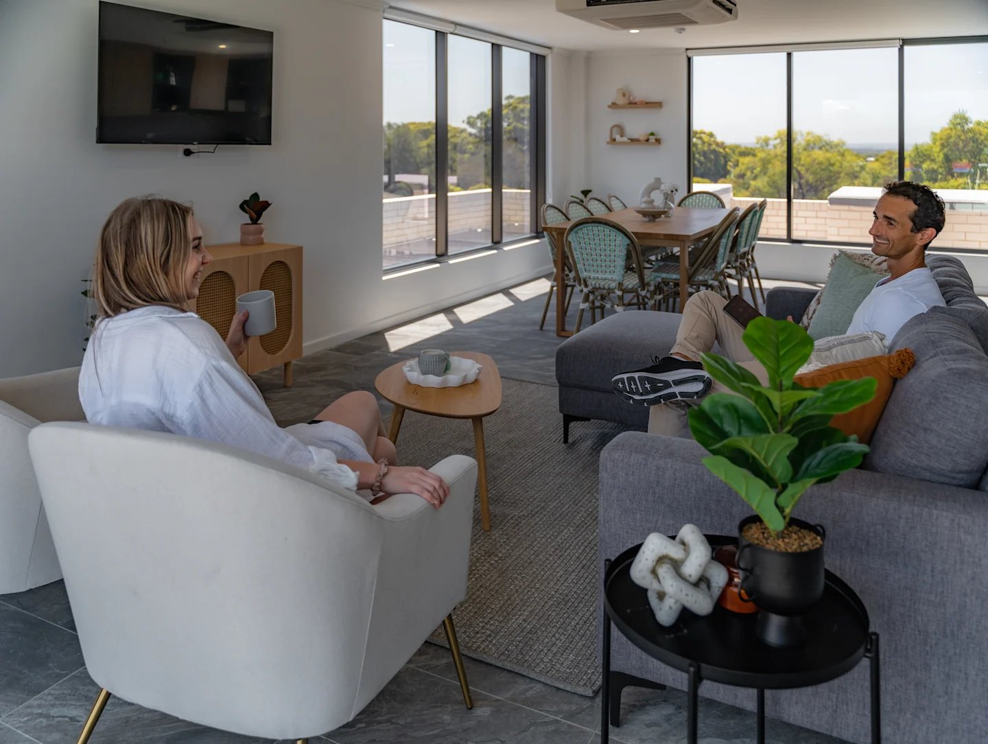 People relaxing in lounge and dining living room at UKO Sutherland in Sydney Student Accommodation