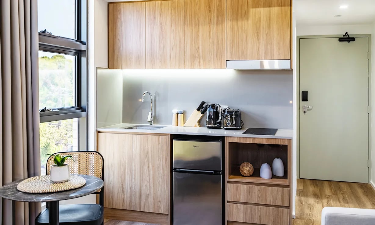 Small kitchen with fridge kettle toaster sink and dining table kitchen at UKO Sutherland in Sydney Student Accommodation