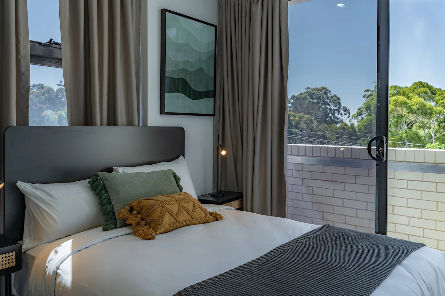 Bed with green and yellow pillows large window Bedroom at UKO Sutherland in Sydney Student Accommodation