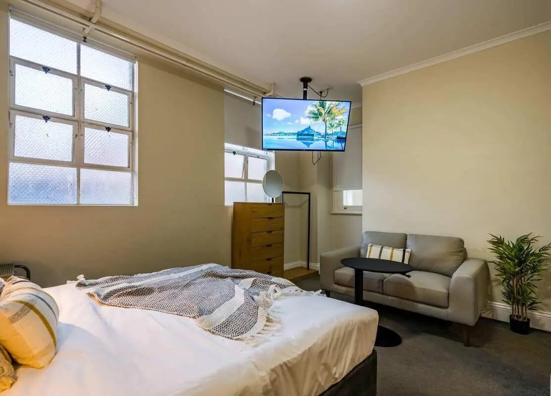 Bed sofa dresser TV and plant bedroom living room at ume Haymarket in Sydney Student Accommodation
