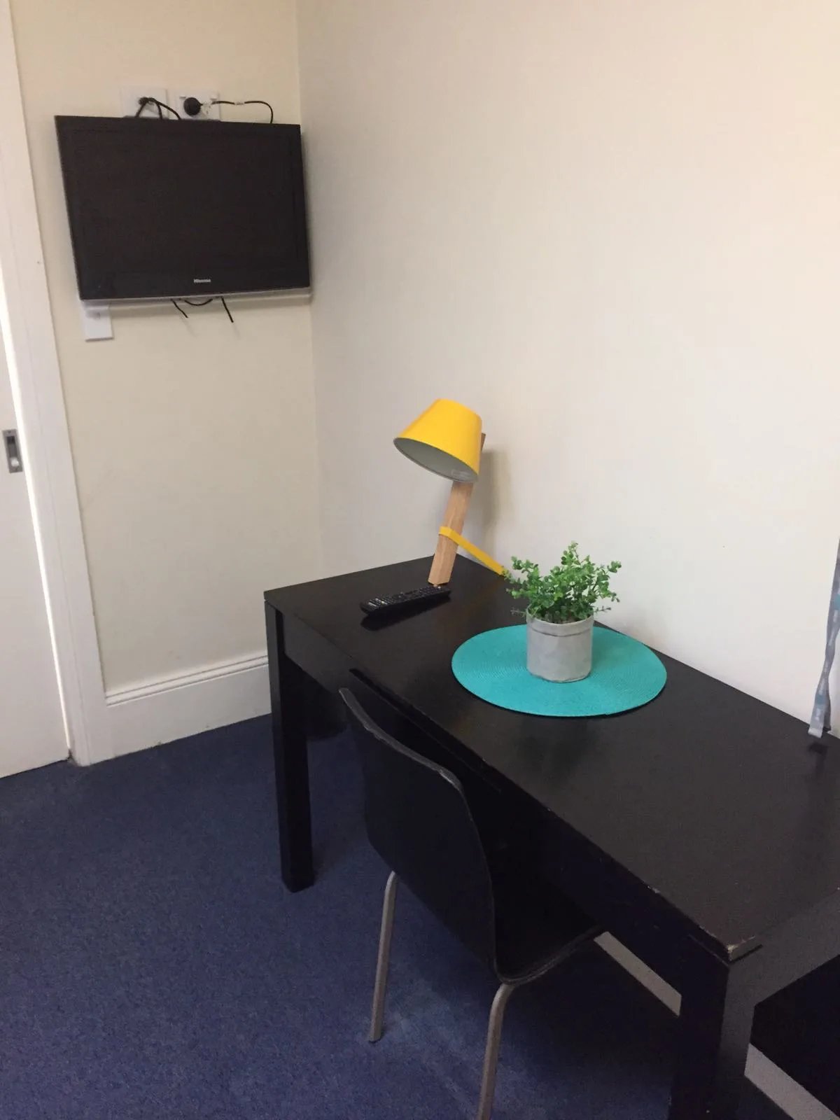 Desk television remote plant and yellow lamp study area at ume Redfern in Sydney Student Accommodation