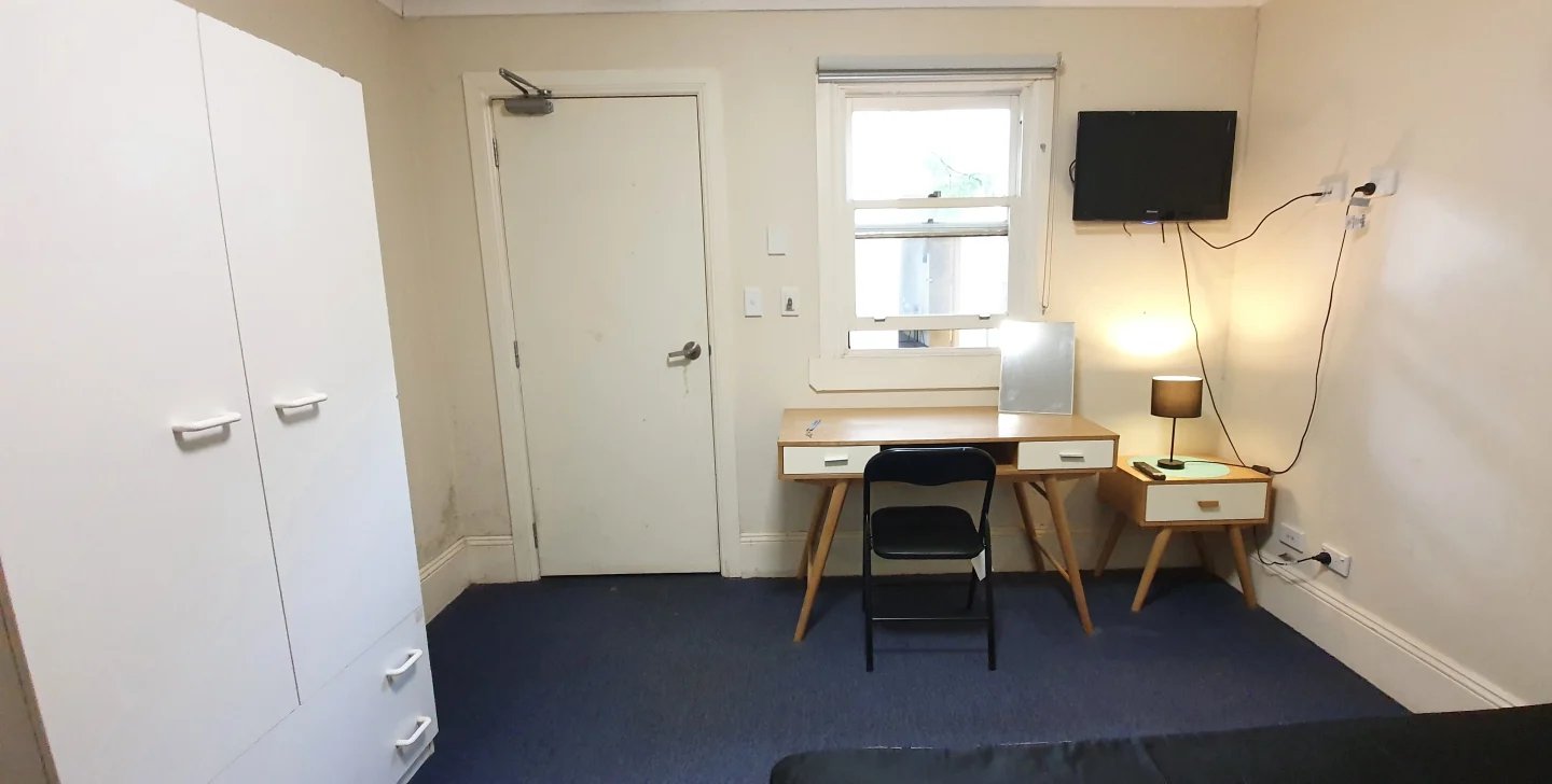 Wardrobe door desk chair TV and lamp bedroom at ume Redfern in Sydney Student Accommodation