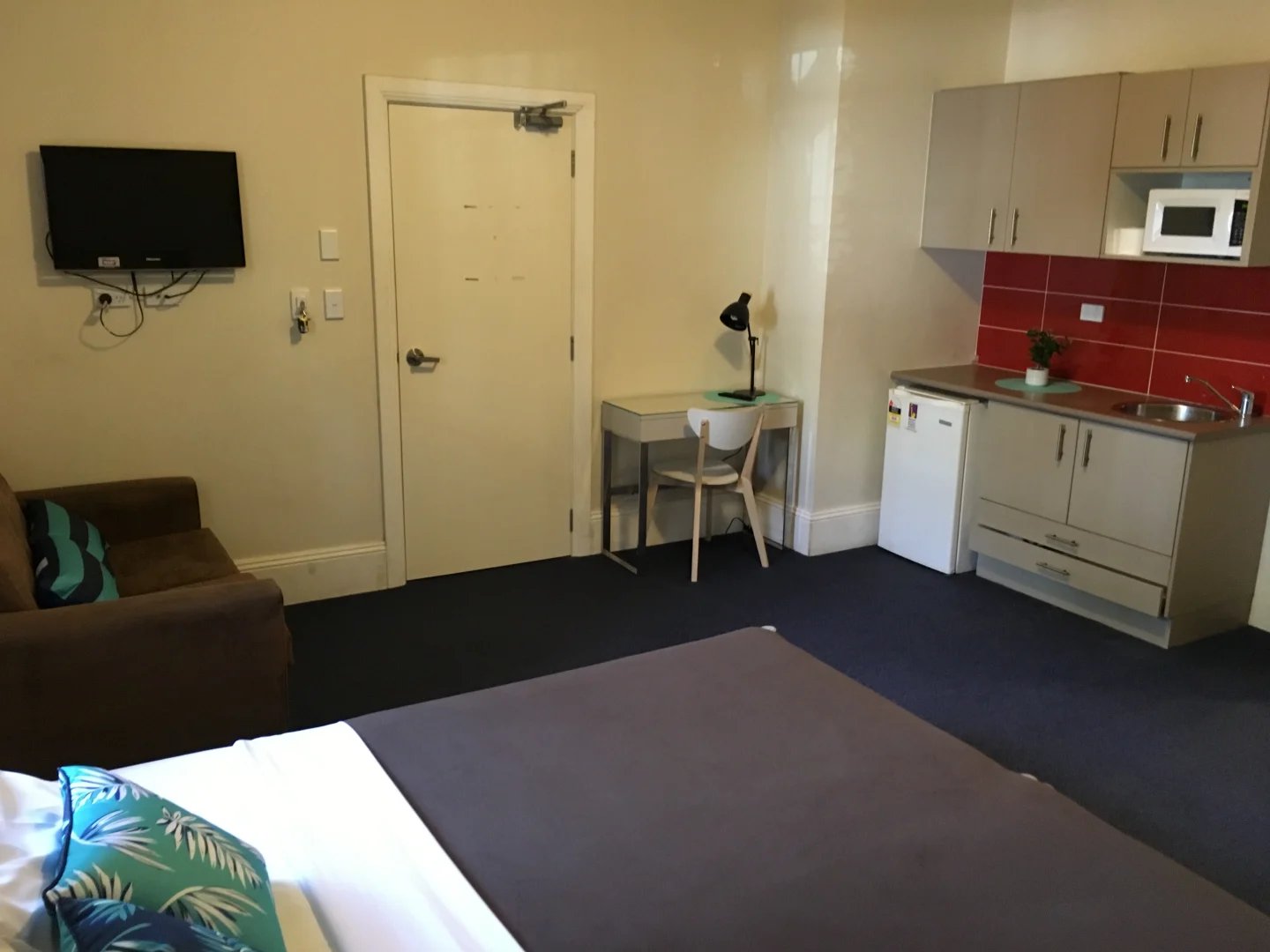 Bed sofa desk microwave kitchen living area exterior at ume Redfern in Sydney Student Accommodation