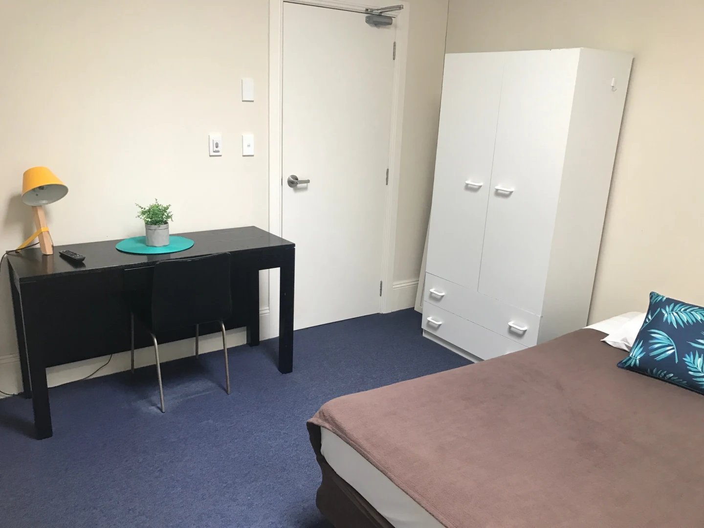 Desk lamp plant wardrobe and bed bedroom at ume Redfern in Sydney Student Accommodation