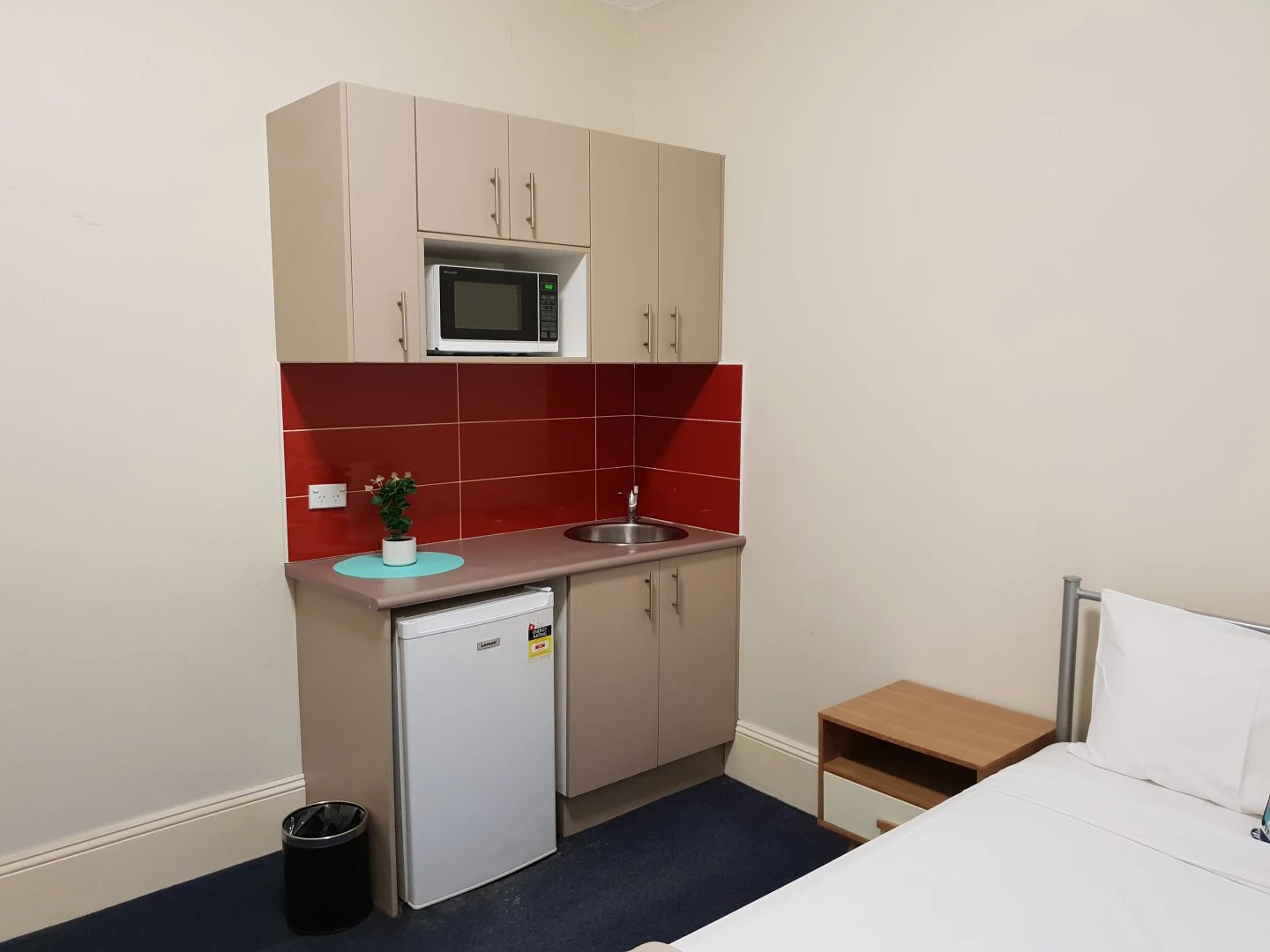 Microwave mini fridge sink cabinets and bed Kitchenette area at ume Redfern in Sydney Student Accommodation