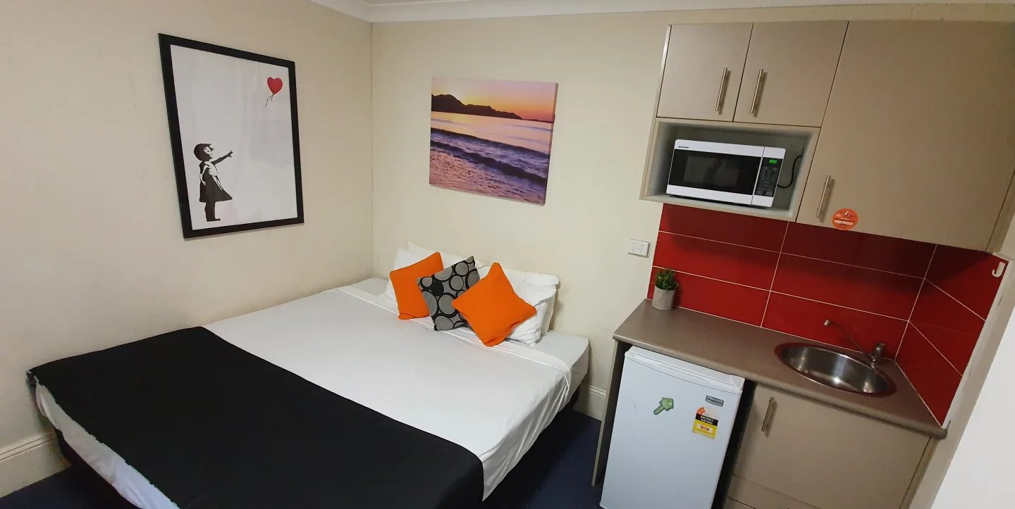 Bed with art mini kitchen microwave and fridge bedroom at ume Redfern in Sydney Student Accommodation