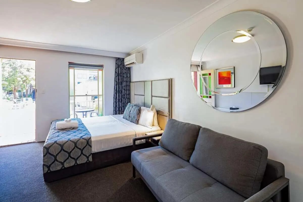 Bed couch and large mirror bedroom at ume Redfern Village in Sydney Student Accommodation