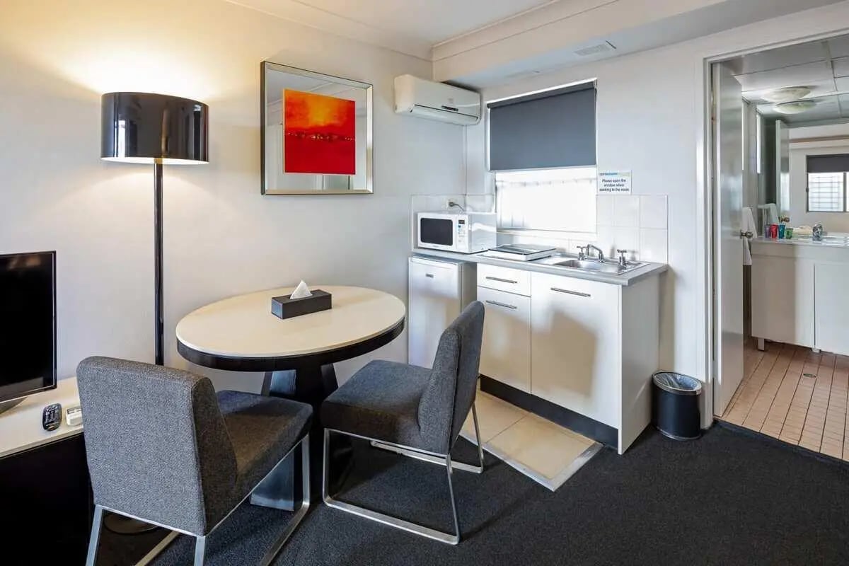 Table chairs lamp kitchen area living room at ume Redfern Village in Sydney Student Accommodation