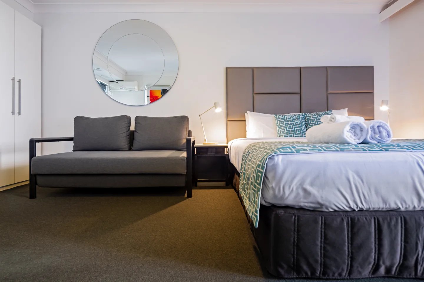 Sofa bed bedside table round mirror bedroom at ume Redfern Village in Sydney Student Accommodation