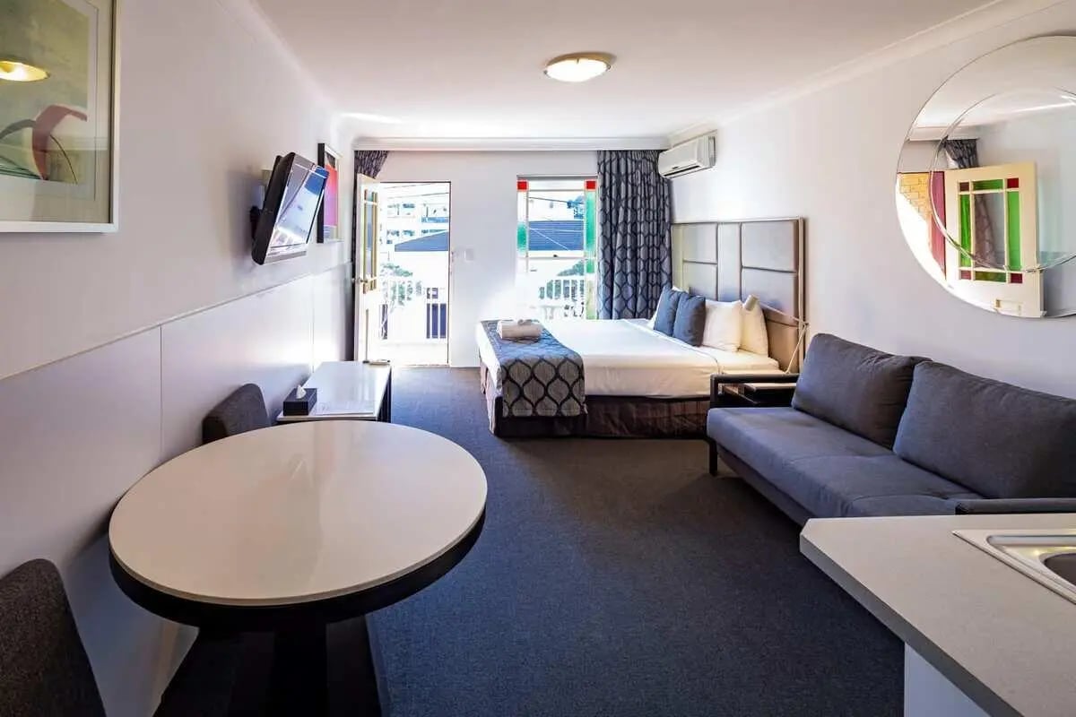 Bed sofa table TV painting and mirror living room at ume Redfern Village in Sydney Student Accommodation