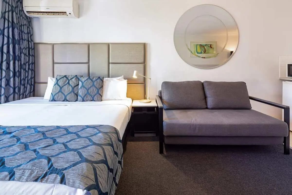 Bed sofa with round mirror bedroom at ume Redfern Village in Sydney Student Accommodation