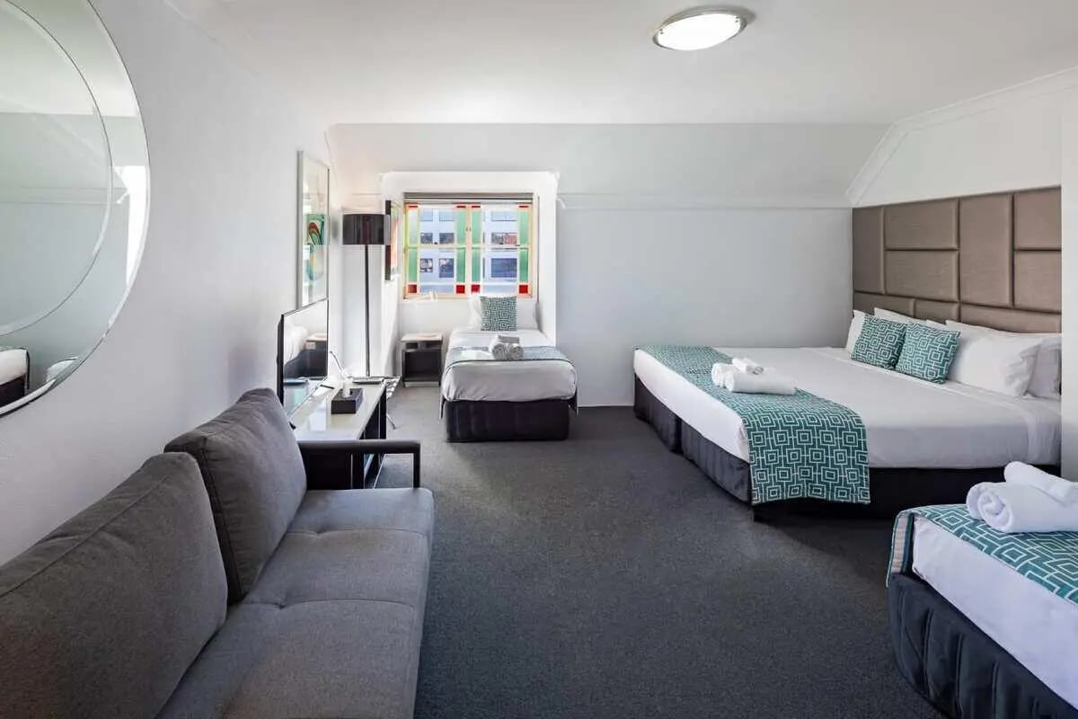 Sofa beds bedside tables and television living room at ume Redfern Village in Sydney Student Accommodation