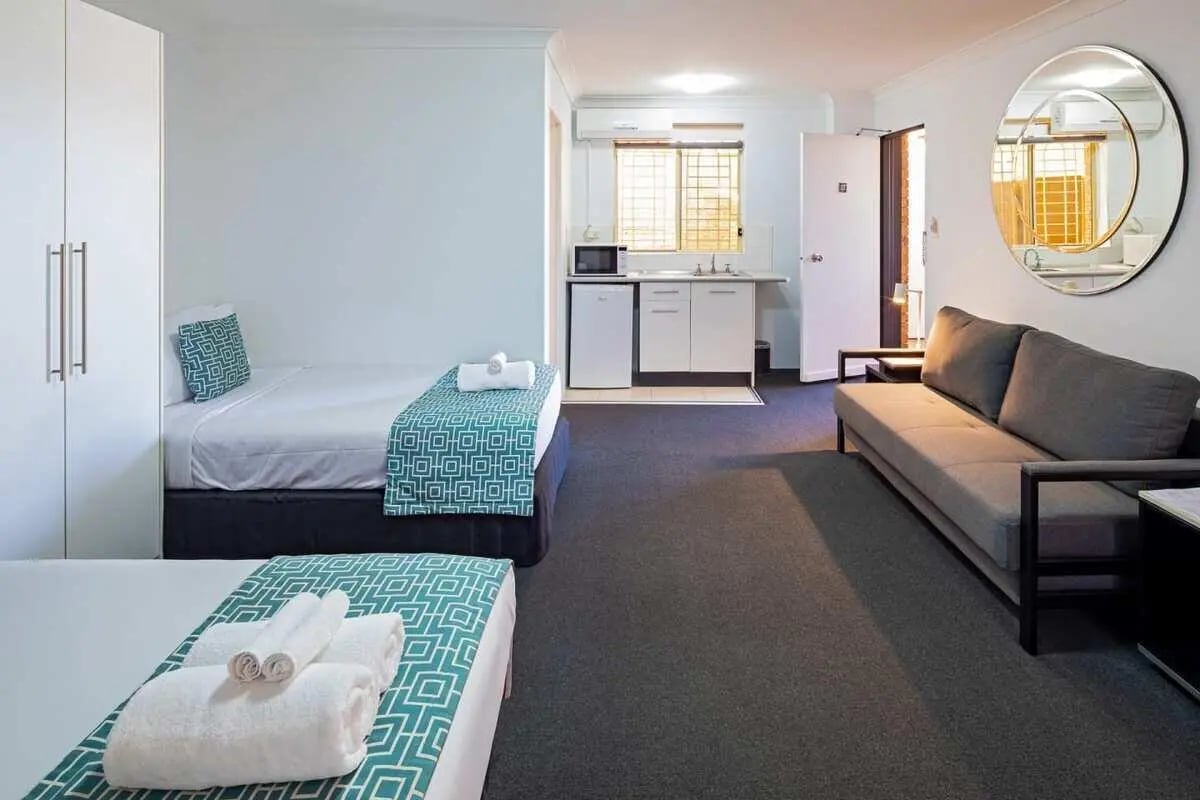 Two beds sofa kitchenette and mirror living room at ume Redfern Village in Sydney Student Accommodation