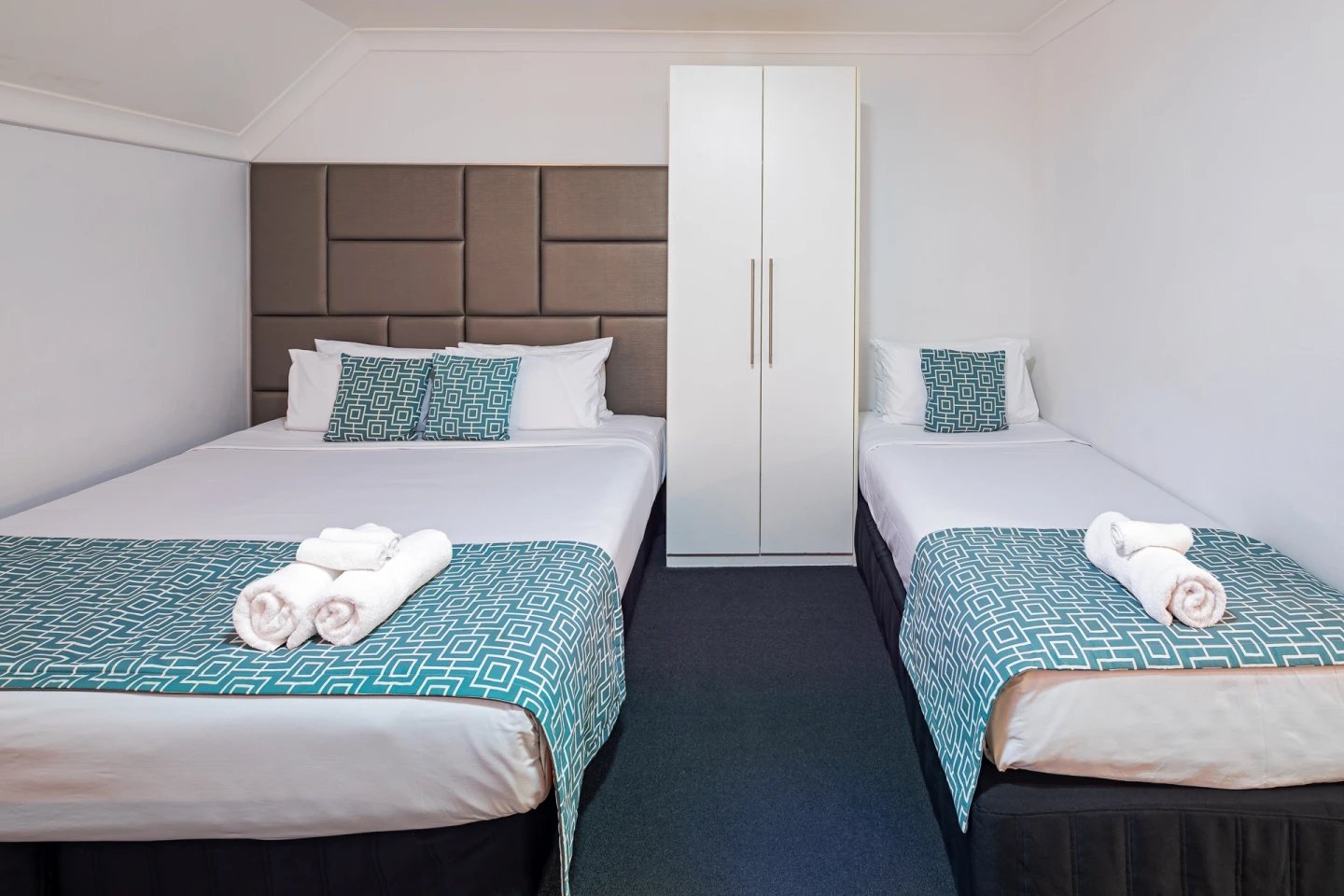 Two beds wardrobe white towels bedroom at ume Redfern Village in Sydney Student Accommodation