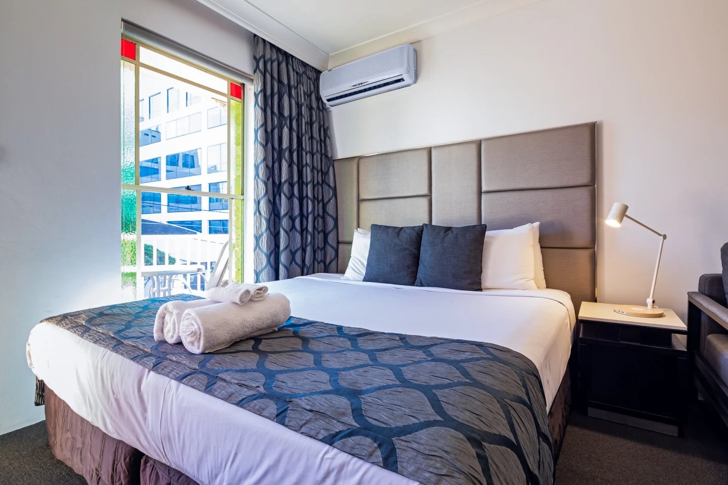 Bed with towels air conditioner lamp bedroom at ume Redfern Village in Sydney Student Accommodation