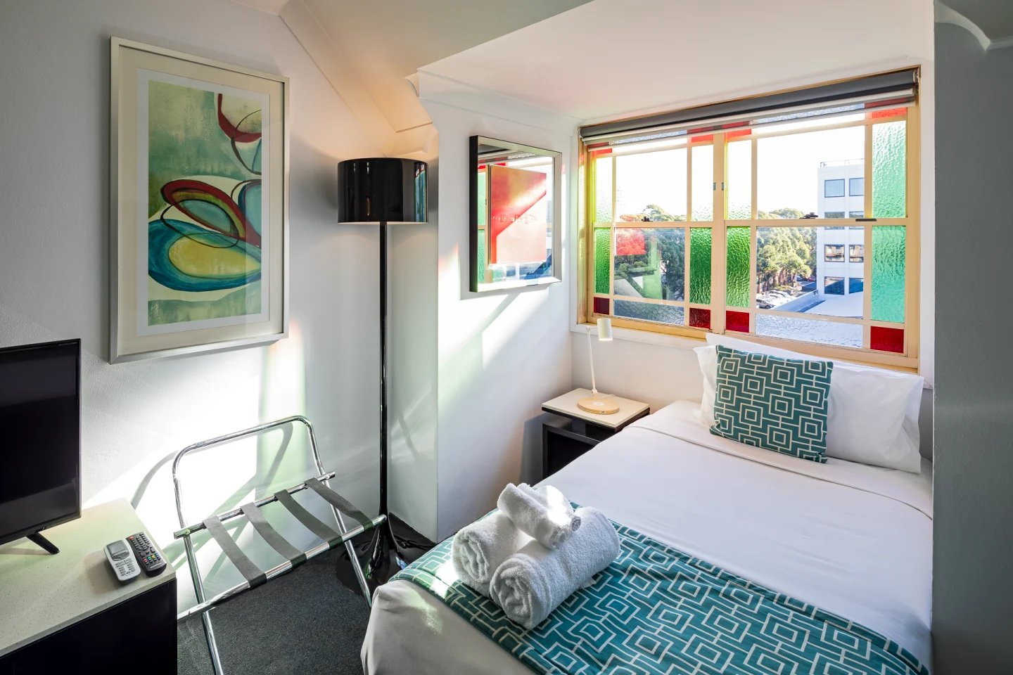 Bed with patterned throw bedside lamp artwork bedroom at ume Redfern Village in Sydney Student Accommodation